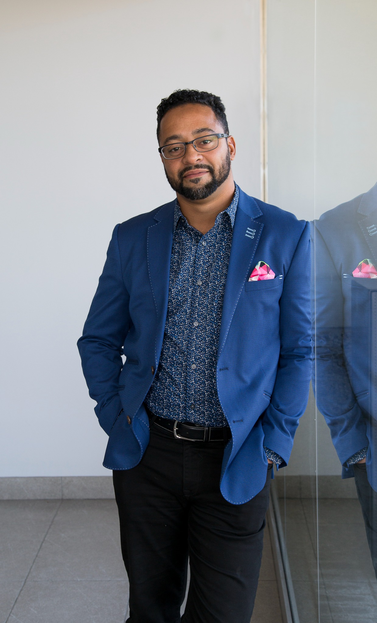 Shawn Gale standing beside a window in a blue jacket